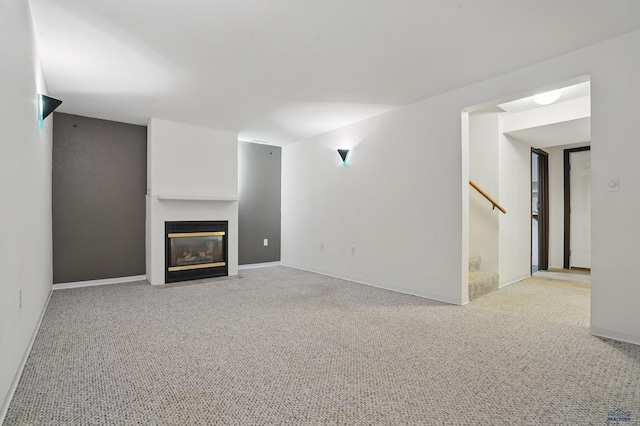 628 Oakland, Rapid City, SD 57701 - unfurnished living room with stairs, carpet flooring, a fireplace with flush hearth, and baseboards