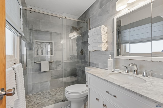 3513 Chapel Valley Rd, Rapid City, SD 57702 - bathroom with tile walls, vanity, toilet, and a stall shower