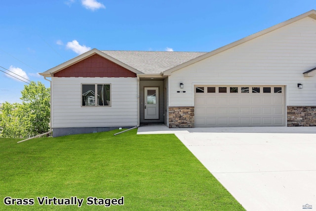 3053 Hoefer Ave, Rapid City, SD 57701 - view of front of home featuring an attached garage, a front yard, driveway, stone siding, and a shingled roof