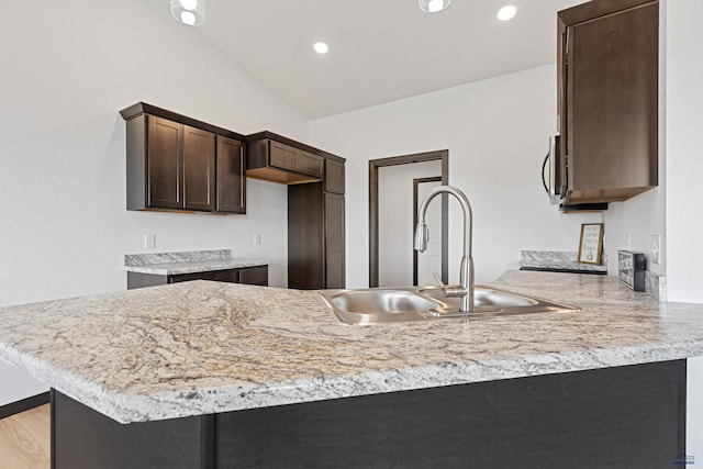 3053 Hoefer Ave, Rapid City, SD 57701 - kitchen featuring a sink, dark brown cabinetry, light countertops, a peninsula, and lofted ceiling