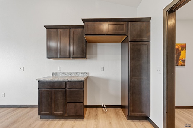 3053 Hoefer Ave, Rapid City, SD 57701 - kitchen featuring dark brown cabinets, light wood finished floors, light countertops, and lofted ceiling