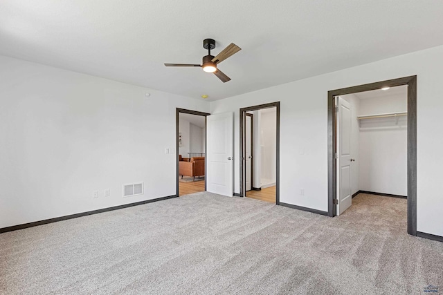 3053 Hoefer Ave, Rapid City, SD 57701 - unfurnished bedroom featuring light colored carpet, a walk in closet, baseboards, and ceiling fan