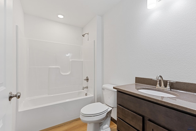 3053 Hoefer Ave, Rapid City, SD 57701 - full bath with toilet, wood finished floors, washtub / shower combination, vanity, and a textured wall