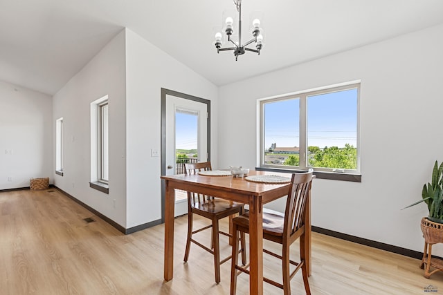 3053 Hoefer Ave, Rapid City, SD 57701 - dining area with lofted ceiling, a chandelier, light wood-style floors, and baseboards