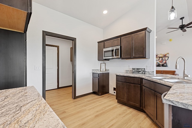 3051 Hoefer Ave, Rapid City, SD 57701 - kitchen with stainless steel microwave, a sink, light wood-style floors, dark brown cabinets, and light countertops