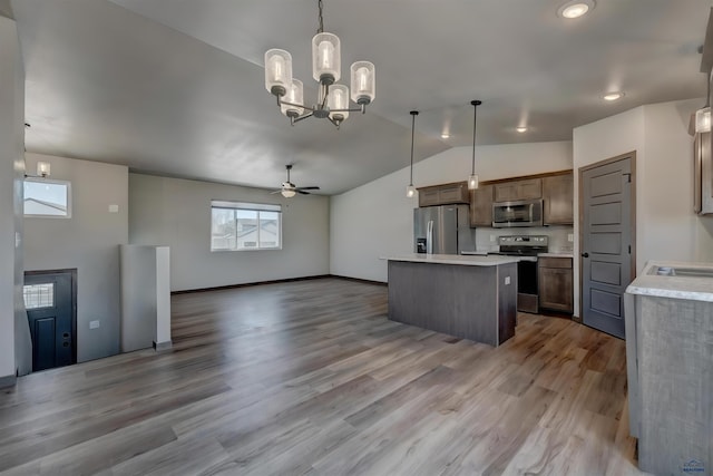 3553 Blackpowder Rd, Rapid City, SD 57703 - kitchen with appliances with stainless steel finishes, a kitchen island, plenty of natural light, lofted ceiling, and light countertops