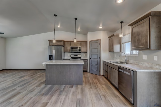 3553 Blackpowder Rd, Rapid City, SD 57703 - kitchen featuring appliances with stainless steel finishes, a sink, vaulted ceiling, light countertops, and light wood-style flooring
