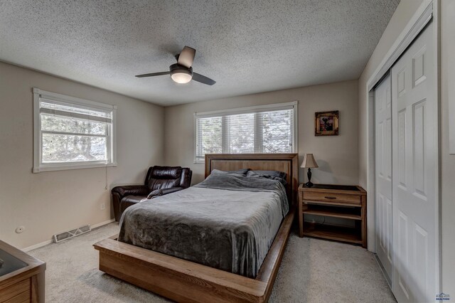 239 Deer Path, Lead, SD 57754 - bedroom featuring carpet, multiple windows, a closet, a textured ceiling, and ceiling fan