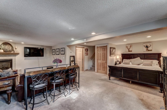 239 Deer Path, Lead, SD 57754 - bedroom with recessed lighting, a textured ceiling, carpet floors, a tile fireplace, and a bar