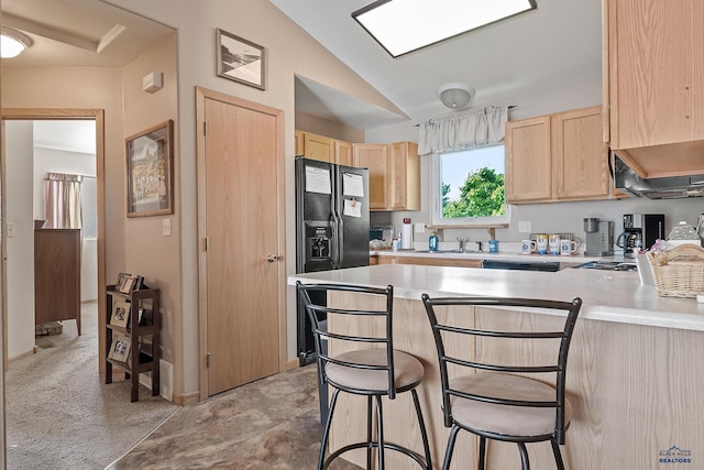 2198 Old Farm Ct, Rapid City, SD 57703 - kitchen with light brown cabinetry, black fridge, a peninsula, light countertops, and vaulted ceiling