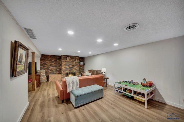 3112 Flint Dr, Rapid City, SD 57702 - living area featuring light wood-style floors, baseboards, a fireplace, recessed lighting, and a textured ceiling