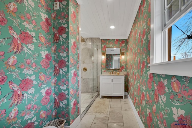 3112 Flint Dr, Rapid City, SD 57702 - bathroom featuring wallpapered walls, marble look tile flooring, baseboards, a stall shower, and vanity