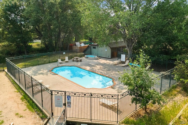 4035 Fairway Hills Dr, Rapid City, SD 57702 - community pool featuring an outdoor structure, a patio, and view of wooded area