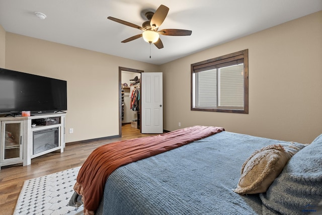 10145 Laramie Ln, Summerset, SD 57718 - bedroom featuring wood finished floors, a spacious closet, a ceiling fan, and baseboards