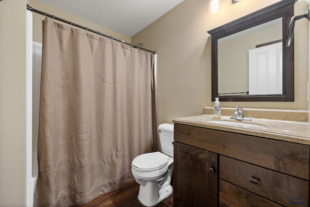 10145 Laramie Ln, Summerset, SD 57718 - bathroom featuring toilet, vanity, a textured wall, a shower with shower curtain, and wood finished floors