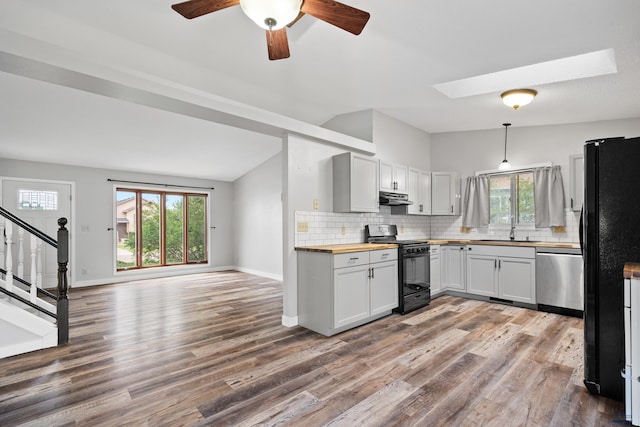 1705 Copperdale Dr, Rapid City, SD 57703 - kitchen featuring black appliances, under cabinet range hood, wooden counters, vaulted ceiling, and wood finished floors
