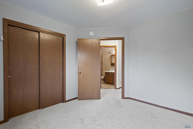 1705 Copperdale Dr, Rapid City, SD 57703 - unfurnished bedroom featuring light carpet, a closet, baseboards, and a textured ceiling