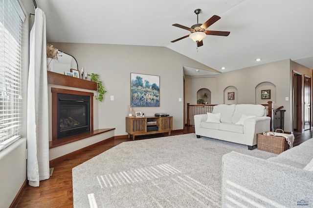 4528 Lahinch St, Rapid City, SD 57702 - living area with ceiling fan, a glass covered fireplace, vaulted ceiling, dark wood-style floors, and baseboards