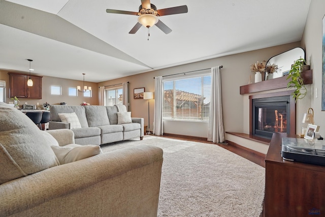 4528 Lahinch St, Rapid City, SD 57702 - living area featuring wood finished floors, a glass covered fireplace, a ceiling fan, vaulted ceiling, and baseboards