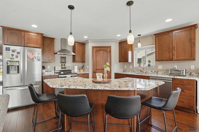 4528 Lahinch St, Rapid City, SD 57702 - kitchen with wall chimney exhaust hood, stainless steel appliances, dark wood finished floors, a kitchen island, and recessed lighting