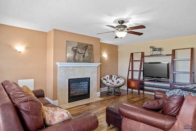 1120 S Regency Ct, Rapid City, SD 57702 - living room featuring wood finished floors, ceiling fan, baseboards, and a tiled fireplace