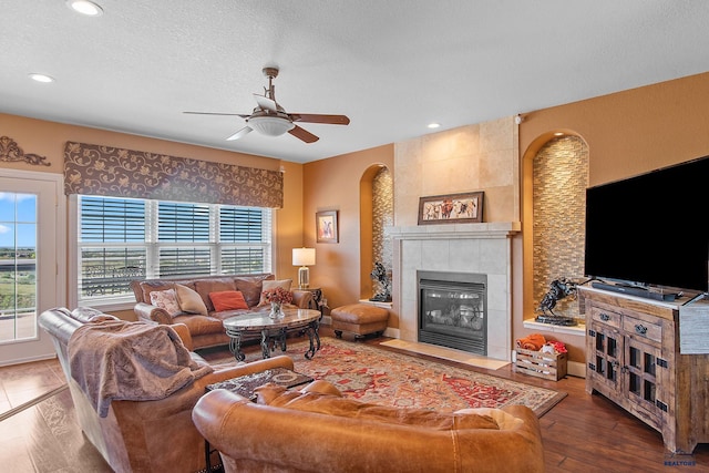 1120 S Regency Ct, Rapid City, SD 57702 - living area with arched walkways, ceiling fan, a fireplace, recessed lighting, and a textured ceiling