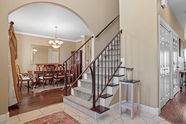 1120 S Regency Ct, Rapid City, SD 57702 - stairs with arched walkways, a chandelier, wood finished floors, baseboards, and crown molding