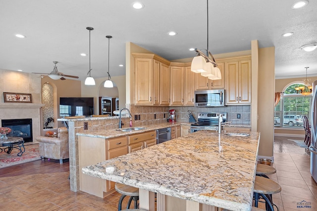 1120 S Regency Ct, Rapid City, SD 57702 - kitchen featuring appliances with stainless steel finishes, a sink, light brown cabinetry, a kitchen bar, and recessed lighting