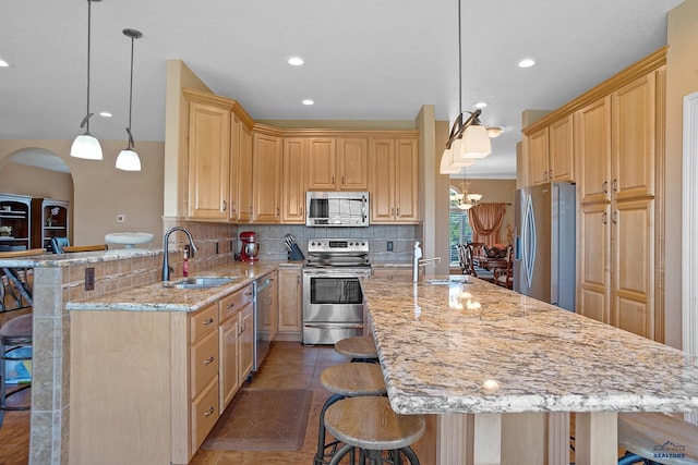 1120 S Regency Ct, Rapid City, SD 57702 - kitchen featuring a sink, stainless steel appliances, a breakfast bar, light brown cabinetry, and recessed lighting