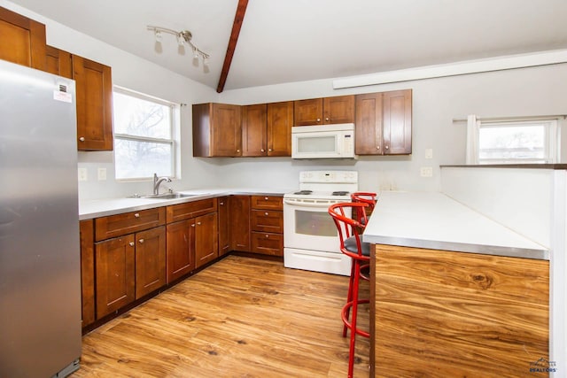 830 Willsie Ave, Rapid City, SD 57701 - kitchen with white appliances, a sink, light wood finished floors, light countertops, and lofted ceiling