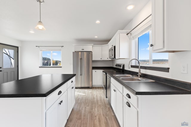 1740 Harmony Heights Ln, Rapid City, SD 57702 - kitchen with appliances with stainless steel finishes, a sink, dark countertops, light wood-style flooring, and recessed lighting