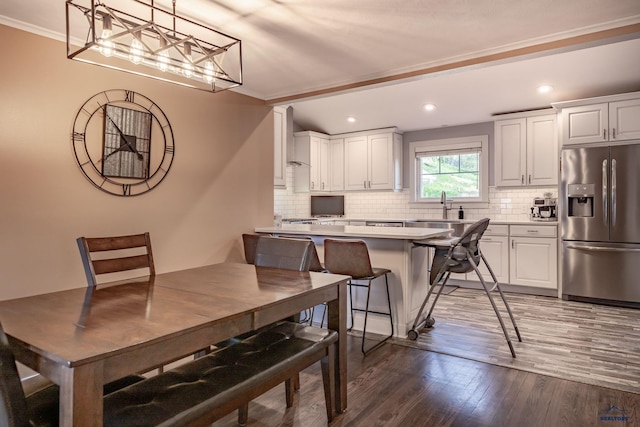 1316 Clark, Rapid City, SD 57701 - kitchen featuring stainless steel fridge with ice dispenser, wood finished floors, tasteful backsplash, crown molding, and light countertops