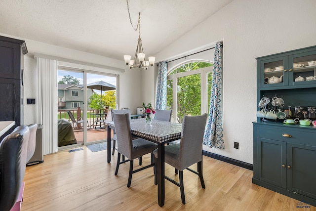 2909 Hoefer Ave, Rapid City, SD 57701 - dining area featuring a chandelier, lofted ceiling, healthy amount of natural light, light wood-style floors, and a textured ceiling