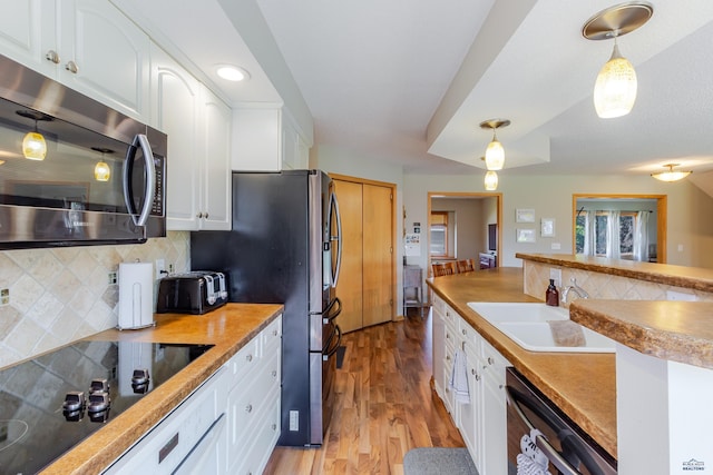 4941 Springtree Ct, Rapid City, SD 57702 - kitchen featuring stainless steel appliances, decorative backsplash, white cabinets, and light wood-style flooring