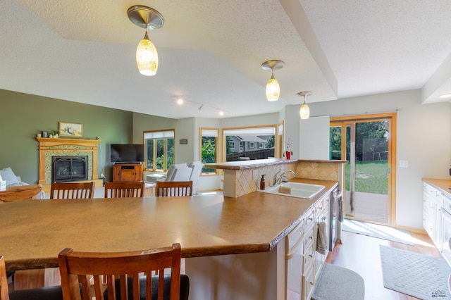 4941 Springtree Ct, Rapid City, SD 57702 - kitchen with healthy amount of natural light, hanging light fixtures, backsplash, a fireplace, and a textured ceiling