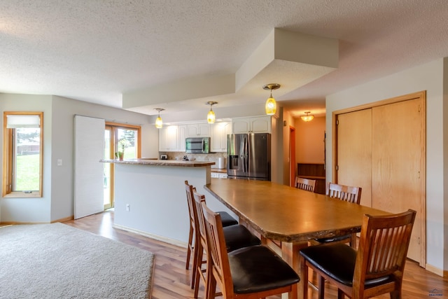 4941 Springtree Ct, Rapid City, SD 57702 - dining area featuring a textured ceiling and light wood-style floors