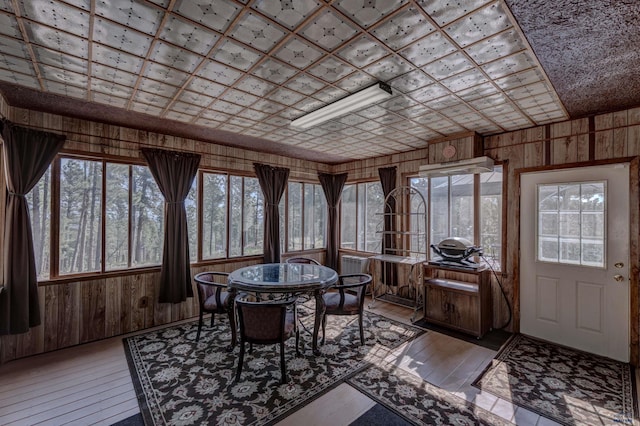 12525 Jax Ct, Rapid City, SD 57701 - sunroom featuring wood walls, healthy amount of natural light, wood-type flooring, and a wooden deck