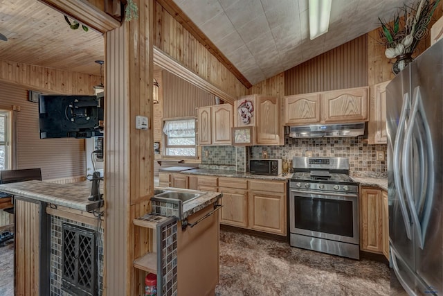 12525 Jax Ct, Rapid City, SD 57701 - kitchen featuring appliances with stainless steel finishes, light brown cabinets, under cabinet range hood, backsplash, and lofted ceiling