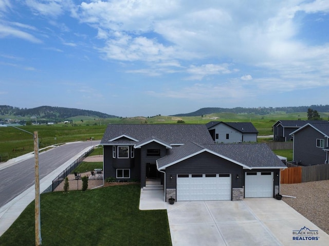 3408 Davenport Loop, Sturgis, SD 57785 - view of front of home with a garage, concrete driveway, a mountain view, and stone siding