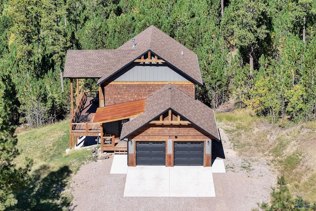 20746 Monte Carlo Rd, Lead, SD 57754 - view of front of house with roof with shingles, a view of trees, a wooden deck, and driveway