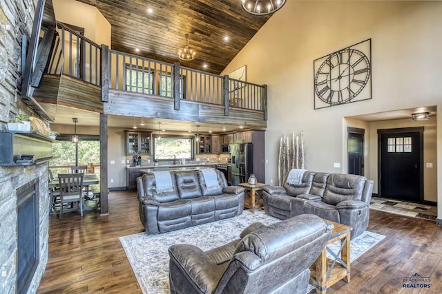 20746 Monte Carlo Rd, Lead, SD 57754 - living area featuring high vaulted ceiling, dark wood-style flooring, wooden ceiling, a stone fireplace, and recessed lighting