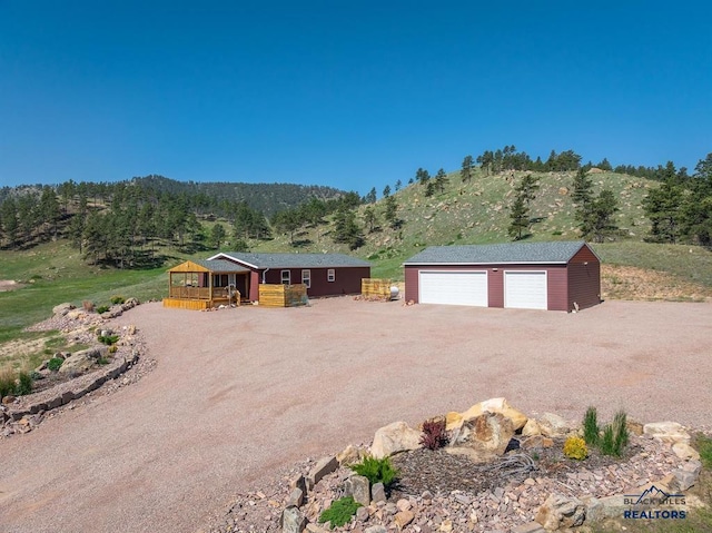 28085 Hargins Rd, Hot Springs, SD 57747 - view of front of house with a detached garage, an outbuilding, and a deck with mountain view