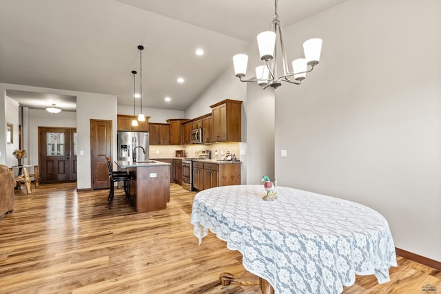 4519 Jolly Ln, Rapid City, SD 57701 - dining space with light wood-style flooring, a chandelier, and vaulted ceiling
