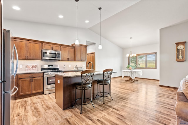 4519 Jolly Ln, Rapid City, SD 57701 - kitchen with stainless steel appliances, lofted ceiling, light wood-type flooring, tasteful backsplash, and a kitchen breakfast bar