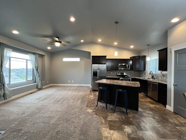 10049 Kaelem Ct, Summerset, SD 57718 - kitchen with appliances with stainless steel finishes, a kitchen island, lofted ceiling, ceiling fan, and tasteful backsplash