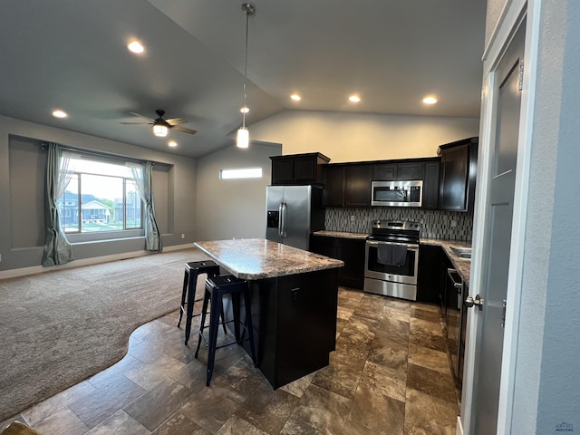10049 Kaelem Ct, Summerset, SD 57718 - kitchen with stainless steel appliances, a kitchen island, open floor plan, lofted ceiling, and a kitchen bar