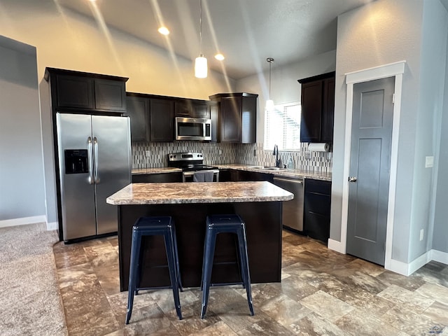 10049 Kaelem Ct, Summerset, SD 57718 - kitchen with stainless steel appliances, a kitchen island, decorative backsplash, a breakfast bar area, and decorative light fixtures