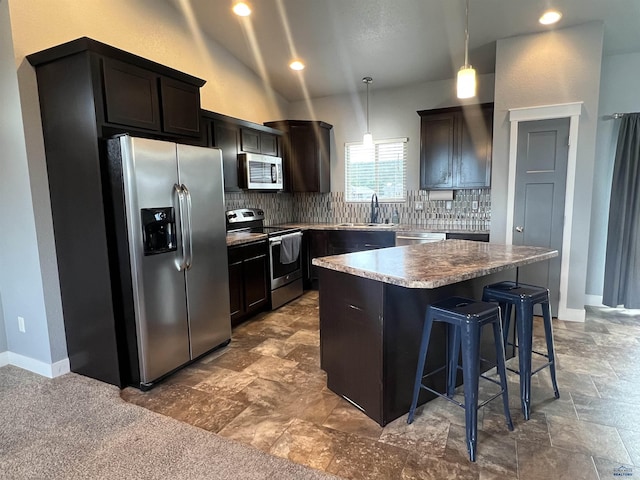 10049 Kaelem Ct, Summerset, SD 57718 - kitchen featuring stainless steel appliances, a kitchen island, backsplash, a breakfast bar area, and pendant lighting