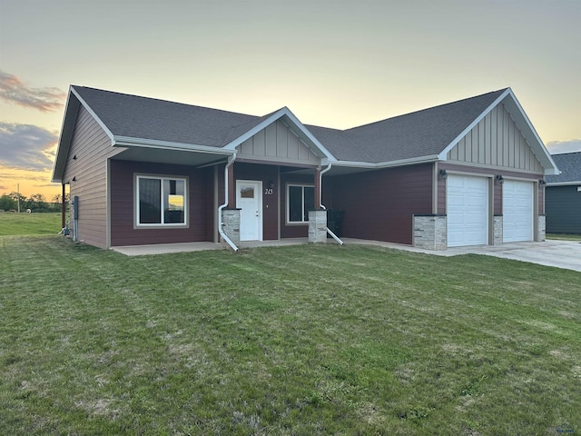 215 Aurora Ave, Spearfish, SD 57783 - view of front facade featuring board and batten siding, a garage, a lawn, and driveway