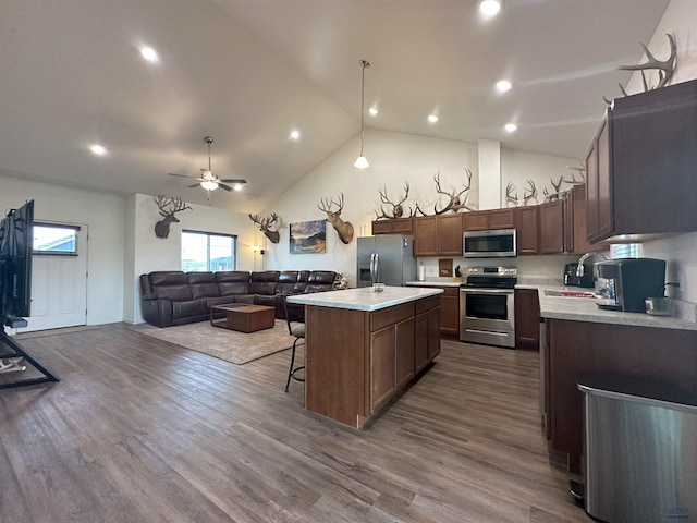 215 Aurora Ave, Spearfish, SD 57783 - kitchen featuring stainless steel appliances, light countertops, open floor plan, a kitchen island, and high vaulted ceiling